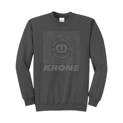 Charcoal long-sleeve crewneck sweatshirt with a large tonal graphic on the chest showcasing the Krone crown, “Hay & Forage Equipment,” and “1973” in a bold square layout