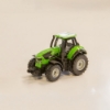 Compact green toy tractor with detailed wheels on light background