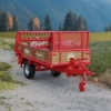 1:32 scale manure spreader model in red and tan on outdoor diorama background