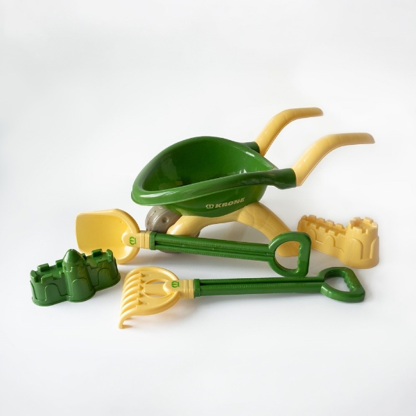 Green and yellow sand toy set including wheelbarrow, shovel, rake, and molds on white background