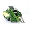 Front angled view of large square baler model with detailed pickup assembly, PTO shaft, and twin axle wheels on white background